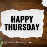 "Happy Thursday blessings text on torn white paper with wooden background and green leaves"